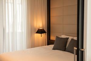 a bedroom with a white bed and a lamp at Point Hotel in Brisbane
