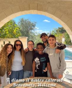 een groep mensen die poseren voor een foto onder een boog bij B&b Aurasia in Ostuni