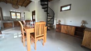 een eetkamer met een houten tafel en stoelen bij D'Sawah Tetebatu Villas in Tetebatu