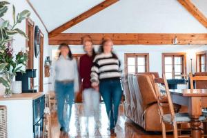 a group of three people walking through a living room at Le Repere du Lac - Lake View Access & Spa in Venise-en-Québec