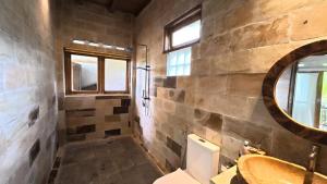 een badkamer met een wastafel, een toilet en een bad bij D'Sawah Tetebatu Villas in Tetebatu +20 foto's