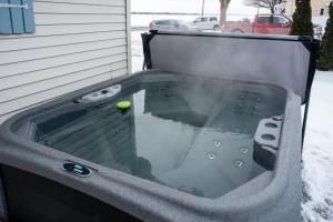 a hot tub with a tennis ball in it at Le Repere du Lac - Lake View Access & Spa in Venise-en-Québec