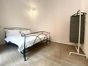 una camera da letto con un letto con lenzuola bianche e una lampada di ARC Apartments Station a Bologna Altre 6 foto