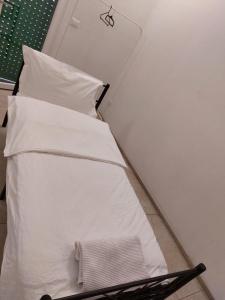 un letto con lenzuola e cuscini bianchi in una stanza di ARC Apartments Station a Bologna