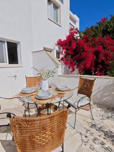 a patio with a table and chairs and flowers at Brand New Townhouse with hotel infrastructure in Paphos