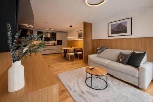 una sala de estar con un sofá y una mesa en Panorama Zillertal Loft - AlpenLuxus Colleciton, en Größing