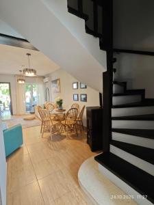 a living room with a staircase and a table and chairs at Brand New Townhouse with hotel infrastructure in Paphos