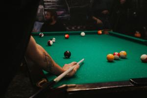 a man playing billiard with a cue on a pool table at El descanso de la Furia in La Porteña