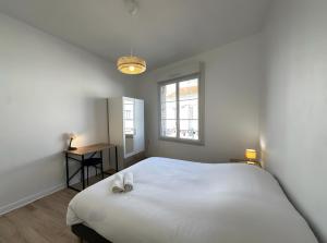 BéthenyDiouf House的卧室里有一张白色的大床和一扇窗户