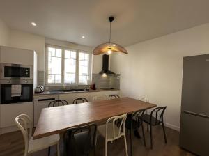 BéthenyDiouf House的厨房里有一张木桌和几把椅子