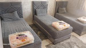 een kamer met drie bedden met matrassen bij شقق الراحة in Oulad Akkou