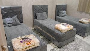 een kamer met drie bedden met matrassen erop bij شقق الراحة in Oulad Akkou
