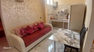 een woonkamer met een bank en een tafel bij شقق الراحة in Oulad Akkou