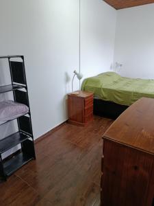 ein Schlafzimmer mit einem Bett und einem Holzboden in der Unterkunft La casita in Minas