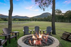 four chairs around a fire pit in a yard at Brokenback Homestead in Pokolbin