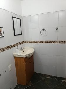 ein Badezimmer mit Waschbecken und Spiegel in der Unterkunft La casita in Minas