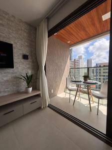 a living room with a table and a large window at Exclusividade e Conforto a 500m da Beira-Mar in Fortaleza