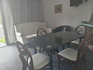 a dining room table with chairs and a couch at Casa de verano 2 in Piriápolis