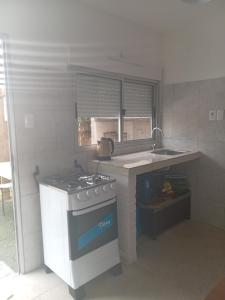 a kitchen with a stove and a sink at Casa de verano 2 in Piriápolis +2 photos