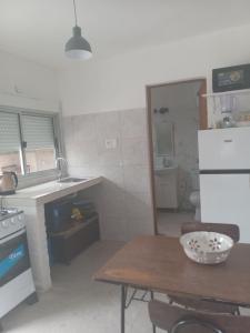 a small kitchen with a table and a sink at Casa de verano 2 in Piriápolis