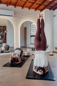 a group of people doing yoga in a room at Pranik Living Wellness Coliving Laureles Medellin in Medellín +56 photos