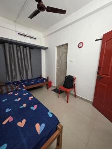 a bedroom with a bed and a chair in a room at FlexTays Transit - Station Side Stays in Trivandrum