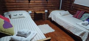 a room with two beds in a log cabin at El mariscal in Gardey