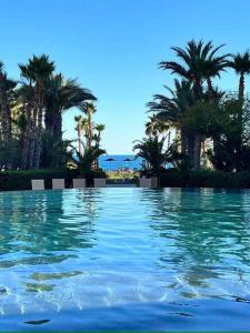 a swimming pool with palm trees in the background at Bella Sirena Resort Premium View Condo in Puerto Peñasco