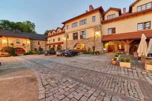 a cobblestone street in front of a large building at Folwark Stara Winiarnia in Mszana Dolna