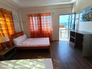 una piccola stanza con un letto e una finestra di Bay Bay Beach Resort 
