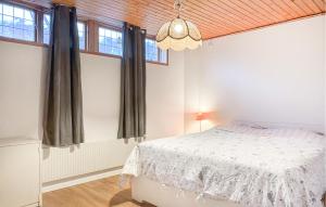 a bedroom with a white bed and windows at 5 Bedroom Nice Home In Motala in Fornåsa