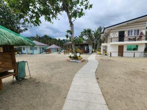 una passerella accanto a un edificio con un albero di Bay Bay Beach Resort 