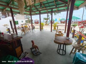 un patio con tavoli e sedie e un cavallo su una sedia di Bay Bay Beach Resort 