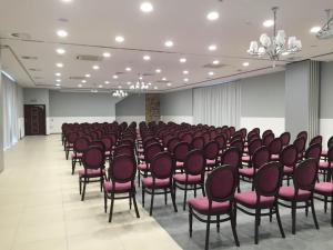 une salle remplie de chaises avec des sièges roses dans l'établissement Hotel Pałac Krotoszyce Basen&Spa, à Krotoszyce