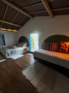 a bedroom with two beds and a window at Casinha do Por do Sol in Caraíva