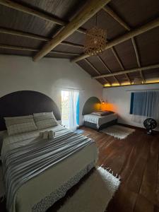 a bedroom with two beds and a chandelier at Casinha do Por do Sol in Caraíva +11 photos