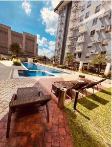 einem Picknicktisch und Bänken vor einem Gebäude in der Unterkunft Vintage Modern Studio Condo Unit with Balcony in Bacolod City