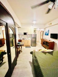 ein Wohnzimmer mit einer Küche und einer Couch darin in der Unterkunft Vintage Modern Studio Condo Unit with Balcony in Bacolod City