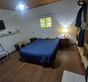 een slaapkamer met een blauw bed en een raam bij Casasdelta in Tigre