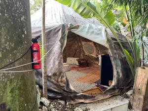 Una tienda de campaña con una boca de incendios roja delante de ella en Casa de Campaña en la Pequeña Selva by Legnalife, en Homestead