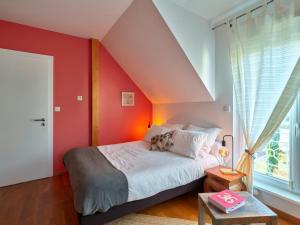 a bedroom with a red accent wall and a bed at BUDA Lodge 6 Alsace Eurométropole Strasbourg in Oberhausbergen