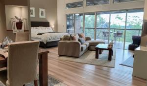 een grote woonkamer met een bed en een bank bij Wild Edge Retreat in Wollombi