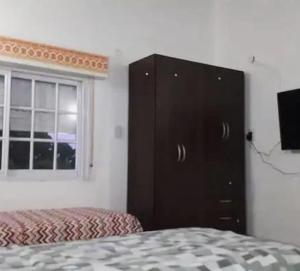 una camera con un comò nero e un letto di Benjamín Relax a Victoria Altre 21 foto