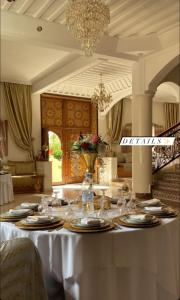 een tafel in een kamer met een witte tafellaken bij Welcome to Riad Glam Marrakech in Marrakesh