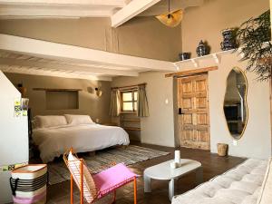 a bedroom with a bed and a living room with a couch at Ombligo Connection House in Valle de Bravo