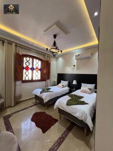 een slaapkamer met twee bedden en een raam bij Welcome to Riad Glam Marrakech in Marrakesh