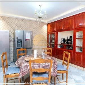 een keuken met een tafel, stoelen en een koelkast bij Welcome to Riad Glam Marrakech in Marrakesh