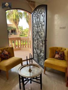 a room with two chairs and a table and a door at Welcome to Riad Glam Marrakech in Marrakesh