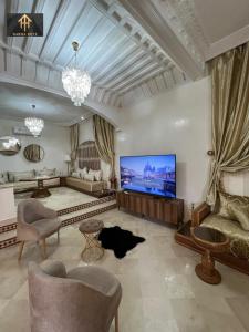 een grote woonkamer met een grote flatscreen-tv bij Welcome to Riad Glam Marrakech in Marrakesh +26 foto's