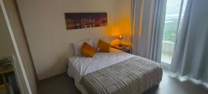 a bedroom with a bed with yellow pillows and a window at Santa marina in Santa Marta +25 photos